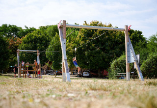 Children playing on a zipline and playground at Camping Le Petit Trianon in Nouvelle-Aquitaine, France.