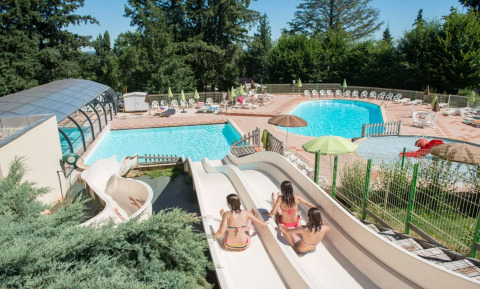 Niños se divierten en los toboganes de agua de Camping Le Sequoia, parque vacacional en Nouvelle-Aquitaine, Francia.