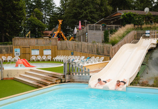 Twee mensen glijden van waterglijbanen bij Camping Le Sequoia in Nouvelle-Aquitaine, Frankrijk.