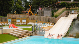 Dos personas se deslizan por toboganes de agua en Camping Le Sequoia, Nouvelle-Aquitaine, Francia.