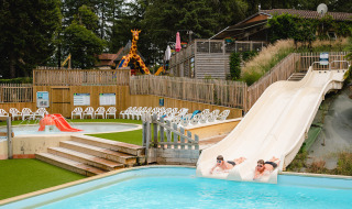 Dos personas se deslizan por toboganes de agua en Camping Le Sequoia, Nouvelle-Aquitaine, Francia.
