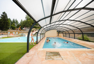 Kinderen spelen in het overdekt zwembad van Camping Le Sequoia vakantiepark in Nouvelle-Aquitaine, Frankrijk.