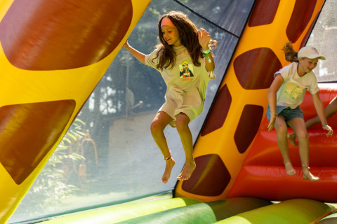 Niños saltan y se divierten dentro de un castillo inflable en Camping Le Sequoia, Nouvelle-Aquitania, Francia.