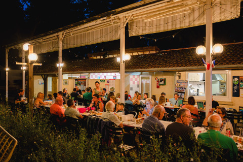 Cena al aire libre por la noche en Camping Le Sequoia, un parque vacacional en Nouvelle-Aquitaine, Francia.