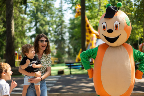 Famille rencontrant la mascotte au parc de Camping Le Sequoia, dans la région Nouvelle-Aquitaine, France.