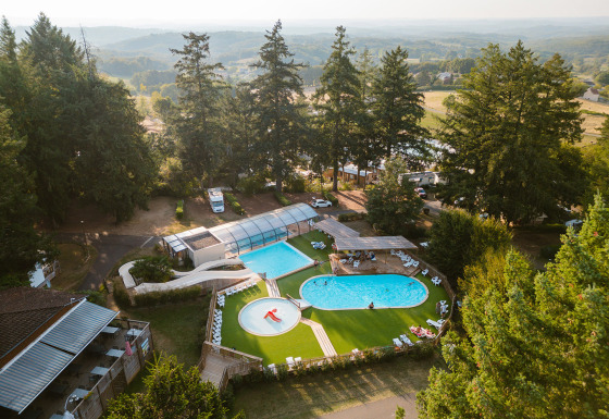 Vista aérea del Camping Le Sequoia en Nouvelle-Aquitaine, Francia, con piscinas y entorno natural.