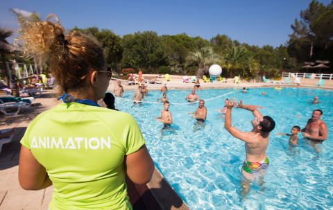 Huéspedes disfrutan juegos acuáticos organizados por un animador en Camping Leï Suves, Provenza, Francia.