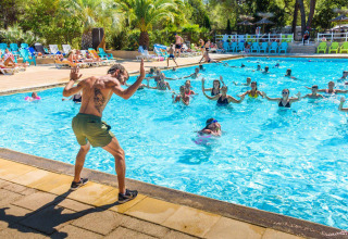 Group water aerobics class led by an instructor at the pool in Camping Leï Suves, Provence-Alpes-Côte d’Azur, France.