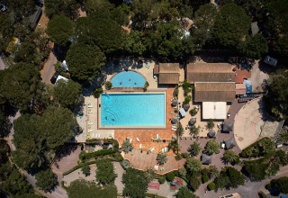 Luchtfoto van Camping Leï Suves in Provence-Alpes-Côte d’Azur met zwembad en ligstoelen in de zon.