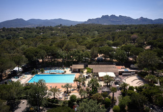 Vista aerea del parco vacanze Camping Leï Suves in Provenza-Alpi-Costa Azzurra, Francia, con piscina e montagne.