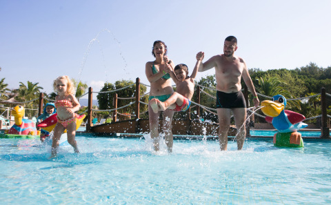 Famiglia che si diverte in piscina per bambini al Camping Leï Suves, villaggio vacanze in Provenza-Alpi-Costa Azzurra, Francia.