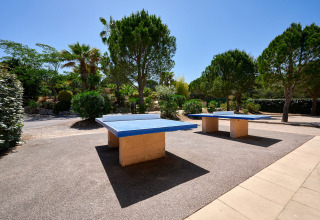 Tavoli da ping pong all'aperto circondati dal verde al Camping Leï Suves in Provenza-Alpi-Costa Azzurra, Francia.