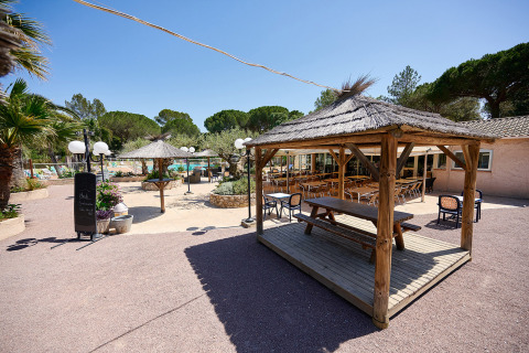 Zona al aire libre con pabellones de paja en Camping Leï Suves, Provenza-Alpes-Costa Azul, Francia.