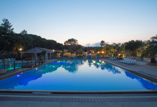 Verlichte zwembad bij zonsondergang op Camping Leï Suves, vakantiepark in Provence-Alpes-Côte d’Azur, Frankrijk.