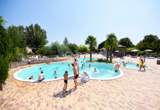 Familier nyder en solrig dag ved udendørs swimmingpoolen på Camping Les Bois du Bardelet i Centre-Val de Loire, Frankrig.