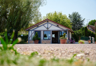 Ingresso di Camping Les Bois du Bardelet in Centre-Val de Loire, Francia, con piante in vaso e bicicletta.