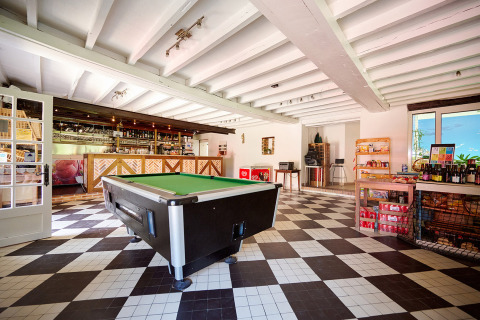 Zona común interior en Camping Les Bois du Bardelet con mesa de billar, bar y tienda en Centre-Val de Loire.