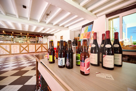 Auswahl an Wein- und Bierflaschen auf einem Tisch in einer modernen Bar im Camping Les Bois du Bardelet, Frankreich.