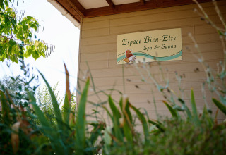 Skilt for 'Espace Bien-Etre Spa & Sauna' ved Camping Les Bois du Bardelet, omgivet af grønne planter.