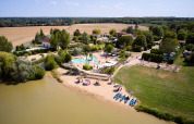 Luftaufnahme von Camping Les Bois du Bardelet mit Pool, Strand, Kanus und grüner Landschaft in Frankreich.