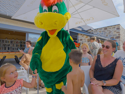 La mascotte intrattiene bambini e famiglie all'aperto al Camping Les Genêts, Occitania, Francia.