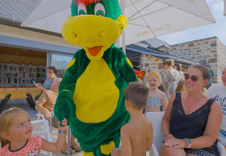 Mascotte vermaakt kinderen en families buiten bij Camping Les Genêts, een vakantiepark in Occitanië, Frankrijk.
