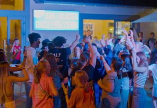 Teenagers having fun and dancing at an evening party at Camping Les Genêts in Occitanie, France.