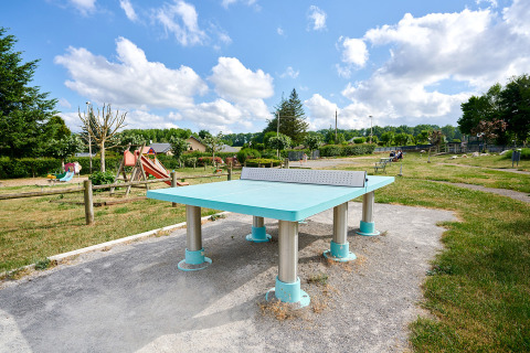 Mesa de ping-pong al aire libre y zona de juegos en Camping Les Genêts, Occitania, Francia.