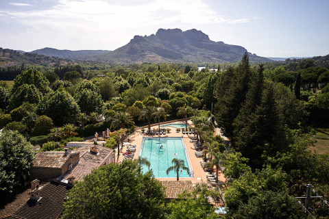 Vista de la piscina de Camping Les Pêcheurs en Provenza-Alpes-Costa Azul, Francia, rodeada de vegetación y montañas.