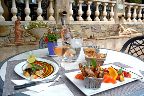 Comida gourmet y vino rosado en una mesa exterior en Camping Les Pêcheurs, Provence-Alpes-Côte d’Azur, Francia.