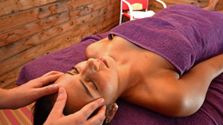 Mujer disfruta de un masaje facial relajante en Camping Les Pêcheurs, parque vacacional en Provenza-Alpes-Costa Azul.