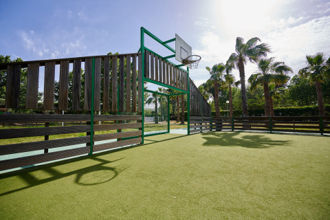 Outdoor basketball court with palm trees in the background at Camping Les Pêcheurs, Provence, France.