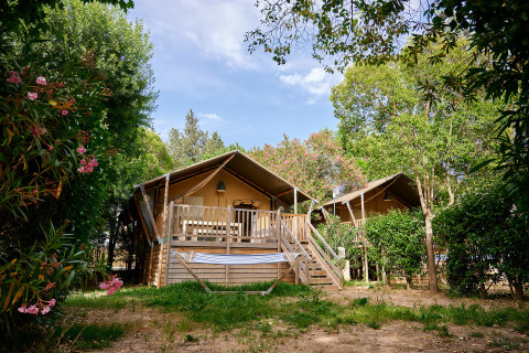 Cabañas de madera con terraza en zona verde de Camping Les Pêcheurs, Provence-Alpes-Côte d’Azur, Francia.