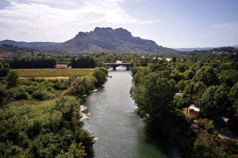 River and mountain view at Camping Les Pêcheurs in Provence-Alpes-Côte d’Azur, France, surrounded by lush greenery.
