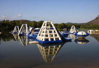Aufblasbare Wasserlandschaft im Camping Les Pêcheurs in Provence-Alpes-Côte d’Azur, Frankreich, mit Bergen.