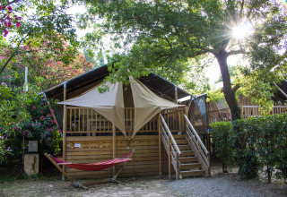 Tenda glamping al Camping Les Pêcheurs in Provenza-Alpi-Costa Azzurra, Francia, tra alberi e amaca.