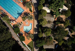 Vue aérienne du Camping Les Pêcheurs avec piscines, transats et arbres dans la région Provence-Alpes-Côte d’Azur.