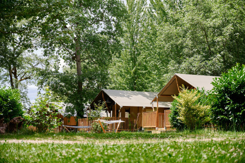 Tiendas glamping entre árboles en Camping Lestaubière, un parque vacacional en Nouvelle-Aquitaine, Francia.