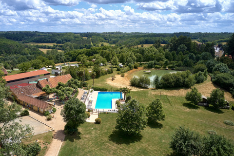 Luchtfoto van Camping Lestaubière in Nouvelle-Aquitaine, Frankrijk, met zwembad, vijver en groene velden.