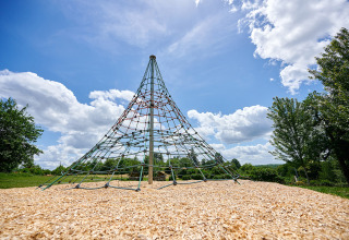 Piramide di corde nell’area giochi del Camping Lestaubière con alberi e cielo in Nouvelle-Aquitaine, Francia.