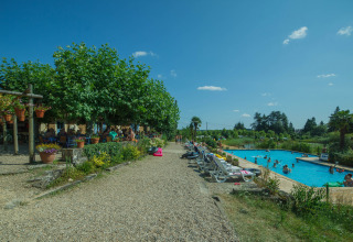 Camping Lestaubière in Nouvelle-Aquitaine, Francia, con piscina, lettini e ospiti che si rilassano al sole.