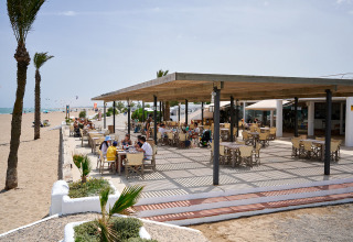Udendørs restaurant ved stranden på Camping Nautic Almata, feriested i Catalonien, Spanien, med gæster