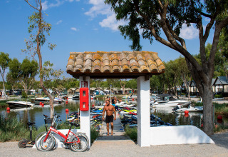 Scorcio di vacanza al Camping Nautic Almata in Catalogna, Spagna, con barche, biciclette e bungalow.