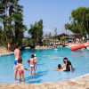 Families with children enjoy the swimming pool at Camping Nautic Almata holiday park in Catalonia, Spain, on a sunny day.