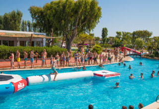 Ospiti si divertono nella piscina con giochi gonfiabili al Camping Nautic Almata, in Catalogna, Spagna.
