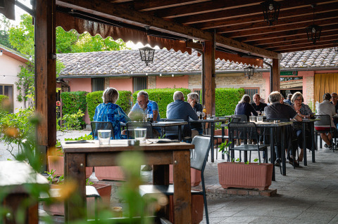 Area ristorante all'aperto al Camping Pian Di Boccio in Umbria, Italia, con ospiti che cenano insieme.