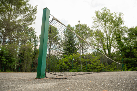 Pista de tenis desgastada en Camping Pian Di Boccio, Umbría, Italia, con una red caída y rota.