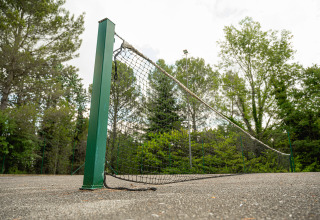 Campo da tennis usurato a Camping Pian Di Boccio, Umbria, Italia, con rete danneggiata e cadente.