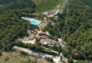 Luchtfoto van Camping Pian Di Boccio vakantiepark met zwembad en bos in Umbrië, Italië.