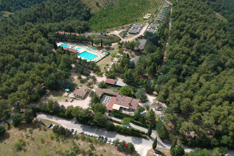 Luftfoto af Camping Pian Di Boccio feriepark med pool og skovomgivelser i Umbrien, Italien.